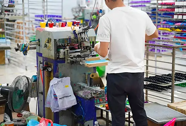 Worker Operating Lanyard Printing Machine in Factory
